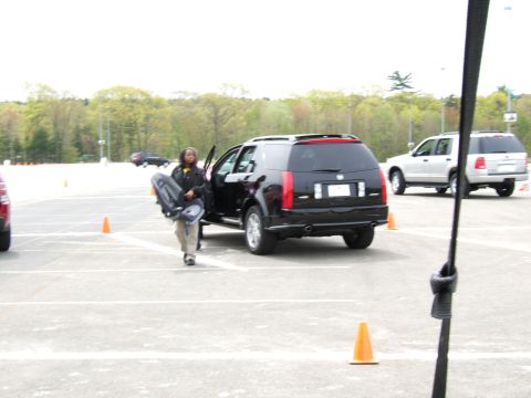 1998 Ford Taurus - A person exits a black Cadillac SRX, carrying a bag, with another SUV visible in the background.