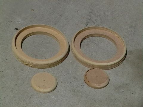 1999 Ford Taurus - Wooden rings and discs, likely for speaker installation, sit on a concrete floor.