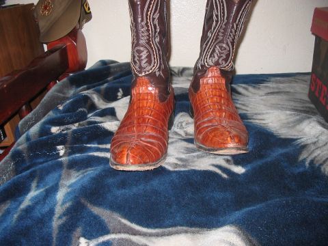1986 Ford Bronco - A pair of cowboy boots with textured alligator skin on the foot and shaft are displayed on a blanket.
