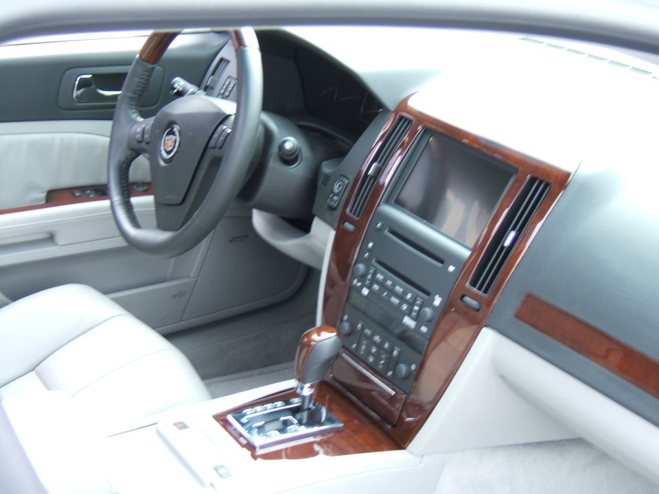 Interior view of a car showing the dashboard, steering wheel, center console with gear shifter, and wood trim