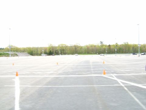 1998 Ford Taurus - A wide shot of a parking lot marked with cones, showing multiple vehicles scattered across the asphalt.