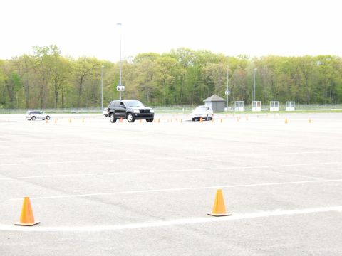 1998 Ford Taurus - Two SUVs navigate a course marked by orange cones on a paved track.