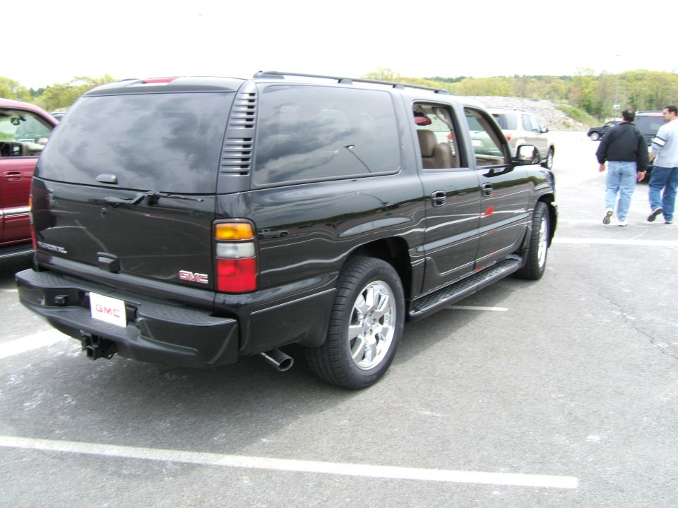 Black GMC Yukon XL Denali SUV rear three-quarter view in a parking lot