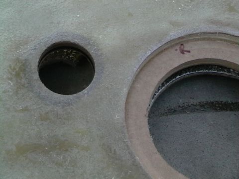 1999 Ford Taurus - A close-up view shows two circular openings within a textured material, one with a small red arrow mark nearby.