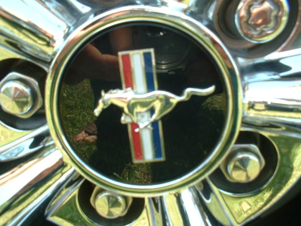 Close-up of a chrome hubcap with a Ford Mustang logo