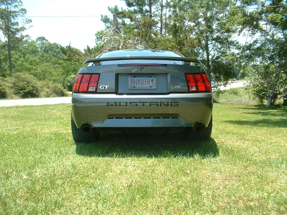 Rear view of a gray 2003 Ford Mustang GT parked on grass
