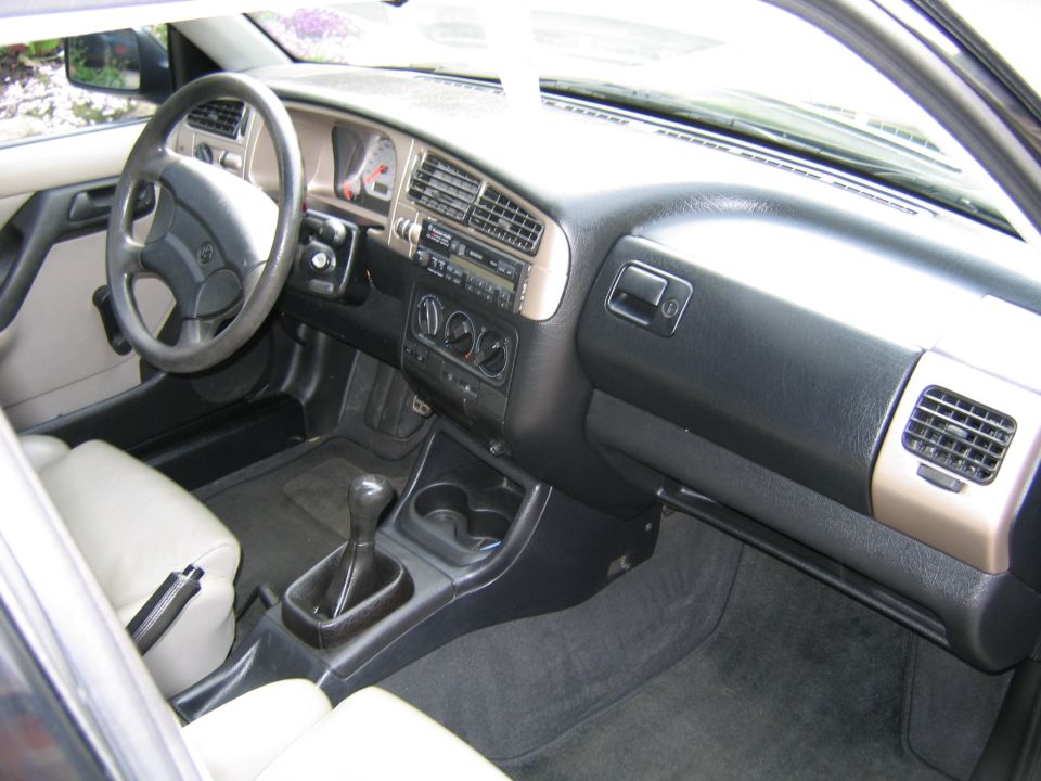 Car interior showing dashboard, steering wheel, gear shifter, and seats. Watermark reads SUPERMOTORS