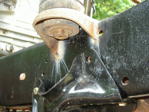 1985 Ford Bronco - Detail of a suspension mount on a vehicle's frame, showing rust and wear.