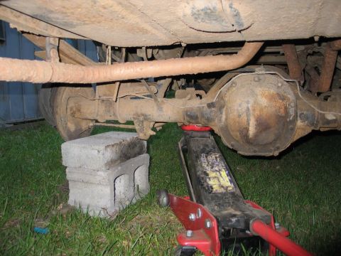 1989 Ford F-150 - Truck's rear axle and suspension components are visible, supported by blocks and a jack.