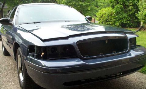 1998 Ford Crown Victoria - Front view of a 1998 Ford Crown Victoria undergoing detailing, with the grille and headlights removed.