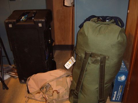 1988 Ford Bronco - Various pieces of luggage are visible, including a large black case and a green duffel bag with tags attached.