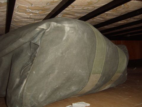 1988 Ford Bronco - A large duffel bag is visible under a bed, with the mattress and frame above.