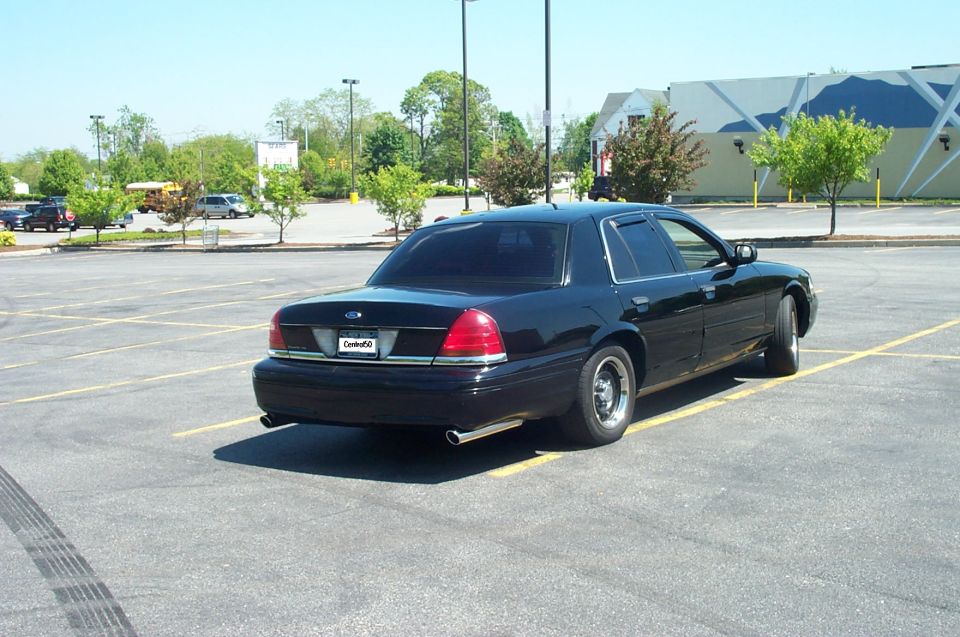 Black Ford Crown Victoria rear three-quarter in a parking lot with dual exhaust