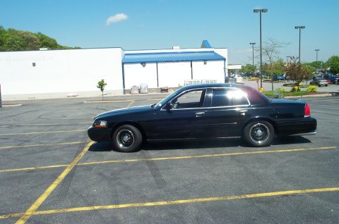 1999 Ford Crown Victoria - Black 1998 Ford Crown Victoria parked in a lot with a building in the background.