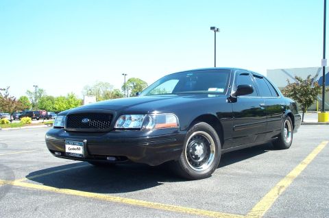 1999 Ford Crown Victoria - This 1999 Ford Crown Victoria features a black grille and weather visors, seen from a three-quarter front view.