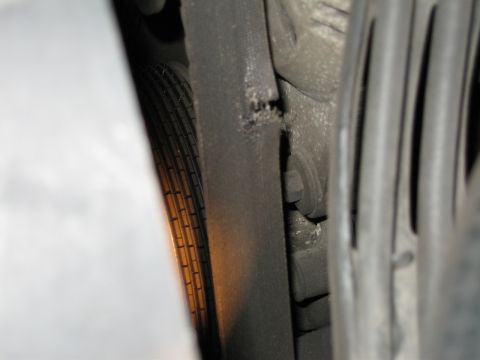 1992 Ford Crown Victoria - Close-up view of a damaged engine belt, showing wear and tear.