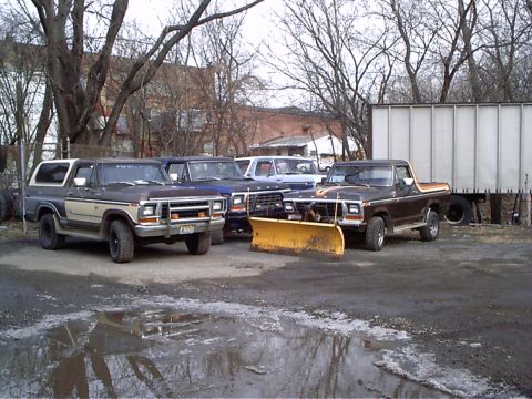 1979 Ford Bronco - A 1979 Ford Bronco is parked in front of other vehicles, equipped with a yellow snow plow.