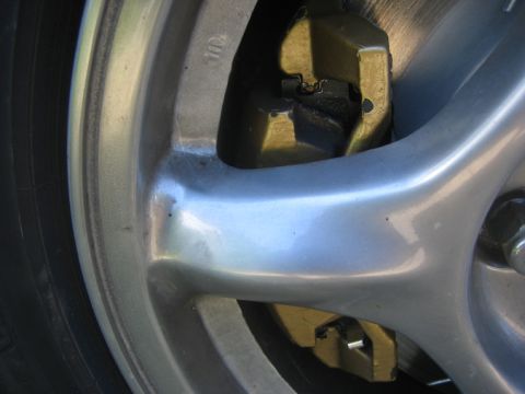 1995 Ford Probe - Close-up of a silver alloy wheel and gold brake caliper.