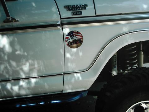 1978 Ford Bronco - Close-up of the fender and door of a white Ford Bronco Ranger XLT, a patriotic decal.