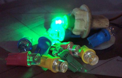 1985 Ford Crown Victoria LTD - A collection of automotive bulbs in red, yellow, green, and blue, with some emitting a bright green light. Text '12V DC' is visible on one…