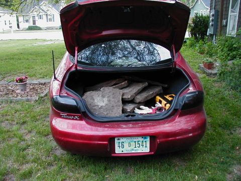 1997 Ford Taurus - This 1997 Ford Taurus is seen from the rear with its trunk open, revealing a load of stones and some tools.