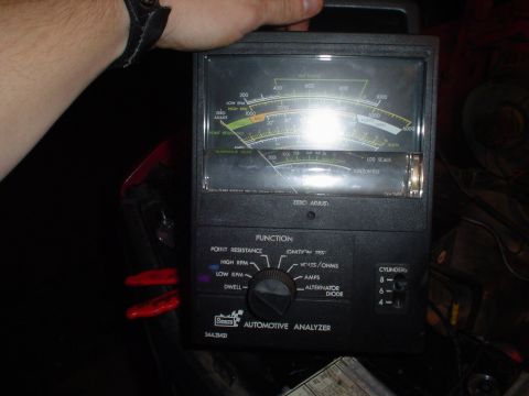 1981 Ford Bronco - An automotive analyzer tool is held, displaying readings on its analog gauge and set to a specific function.