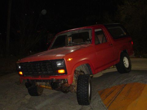 1981 Ford Bronco - A red 1981 Ford Bronco is parked outdoors at night.