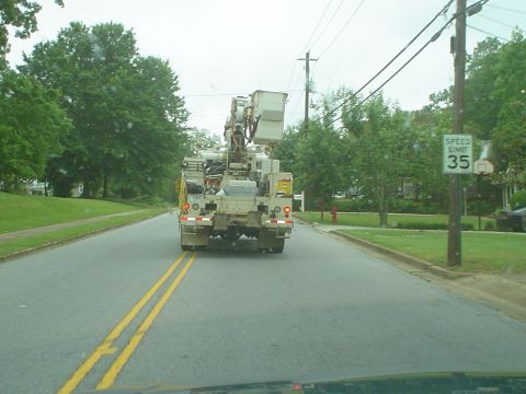 1981 Ford Bronco - A utility bucket truck is seen from behind on a road with a speed limit of 35 mph.