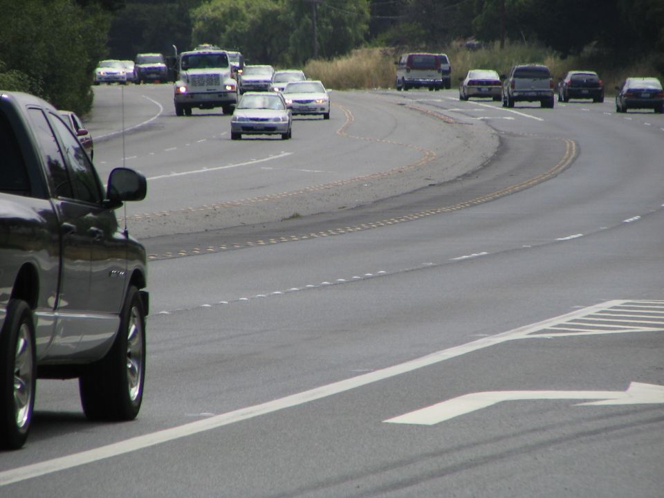 Dark pickup truck side view on a highway with other vehicles