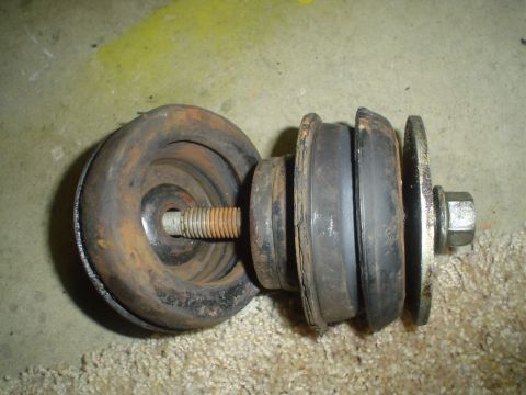 1993 Ford Taurus - A worn suspension component, likely a strut mount, shows signs of age and rust.