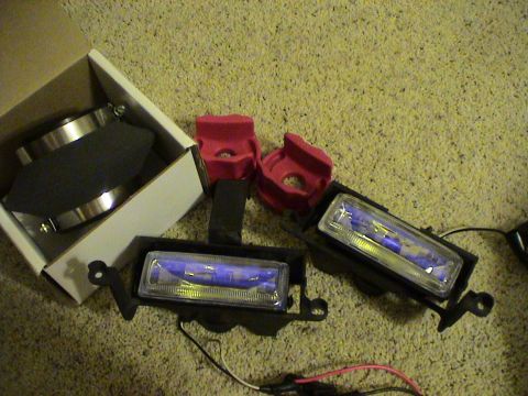1997 Ford Probe - Unboxed fog lights and air intake components are laid out on a carpeted floor, with one fog light still in its original packaging.