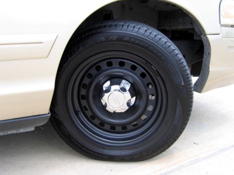 2000 Ford Crown Victoria - Steel wheel with a chrome hubcap and Goodyear Assurance tire.