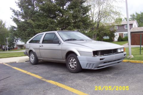 1983 Volkswagen Scirocco - A silver hatchback is parked in a lot, showing its front end with the bumper missing.