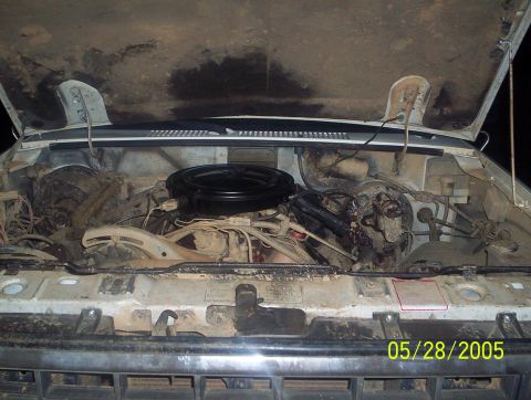 1984 Ford Bronco II - The engine bay of a vehicle is shown with the hood open, revealing the air cleaner and various hoses and components.