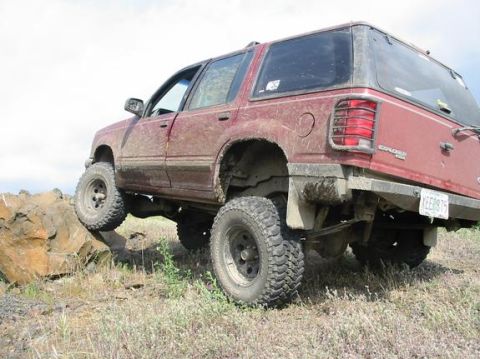1991 Ford Explorer - This modified Ford Explorer is tackling a rocky trail, demonstrating its off-road capabilities.