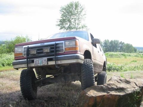 1991 Ford Explorer - This 1991 Ford Explorer is shown with a lifted suspension and oversized tires, navigating rocky terrain.