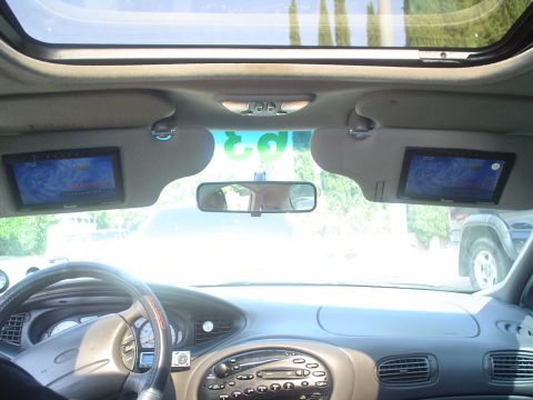 1993 Ford Taurus - Interior view of a car, showing the dashboard, steering wheel, and sunroof, with screens integrated into the sun visors.