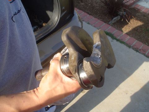 1993 Ford Taurus - A person holds a damaged crankshaft, likely removed from an engine.