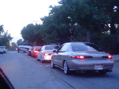 1993 Ford Taurus - A line of cars, including a tan sedan, are stopped in traffic on a street.