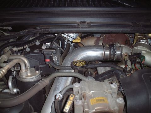 2000 Ford Excursion - The engine bay of a 2000 Ford Excursion shows complex mechanical components and a large intake pipe.