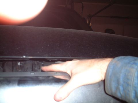 2000 Ford Excursion - A hand is shown reaching into the engine bay of a 2000 Ford Excursion, likely for an oil change.