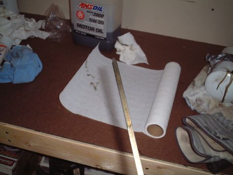 2000 Ford Excursion - Supplies for an oil change are laid out on a workbench, including a dipstick and motor oil.