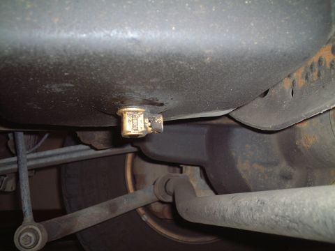 2000 Ford Excursion - Close-up of an oil drain plug on the underside of a vehicle.