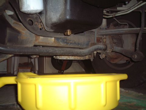 2000 Ford Excursion - Performing an oil change on a 2000 Ford Excursion, showing the oil pan and filter assembly.