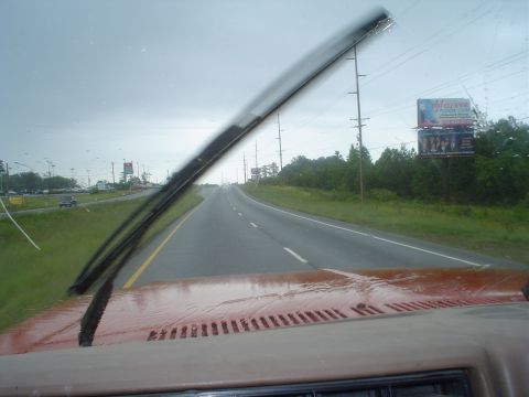 1981 Ford Bronco - Driving on a highway during a rain shower, with wipers active.