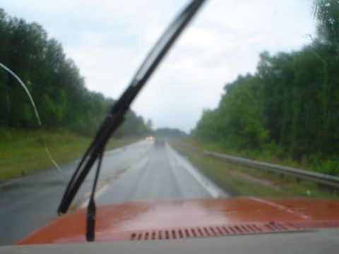 1981 Ford Bronco - Driving down a highway on a cloudy, rainy day, looking out through the windshield.