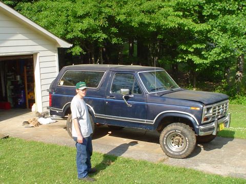 1981 Ford Bronco - A dark blue Ford Bronco is parked outside a garage with a person standing next to it.