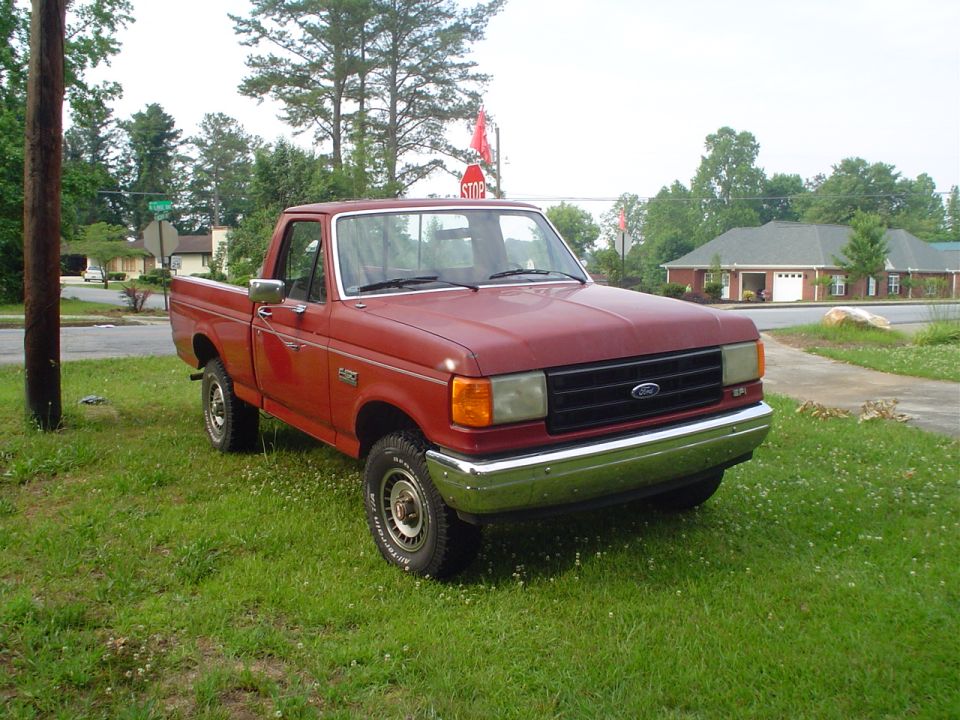 Red pickup truck, 3q-front view. Likely 1987 Ford F-150