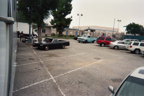 1968 Ford Mustang - A black pickup truck with red accents is parked in a lot with other vehicles.