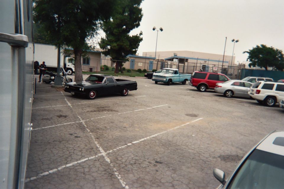 Black pickup truck with red wheel trim and a red interior, seen from the side
